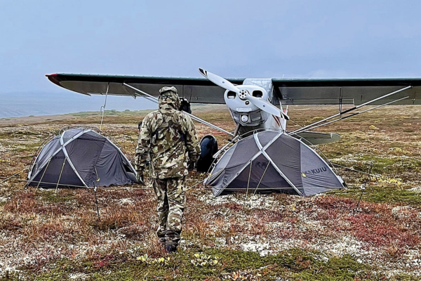 Remote fly-out hunting camp in Alaska with tents and bush plane